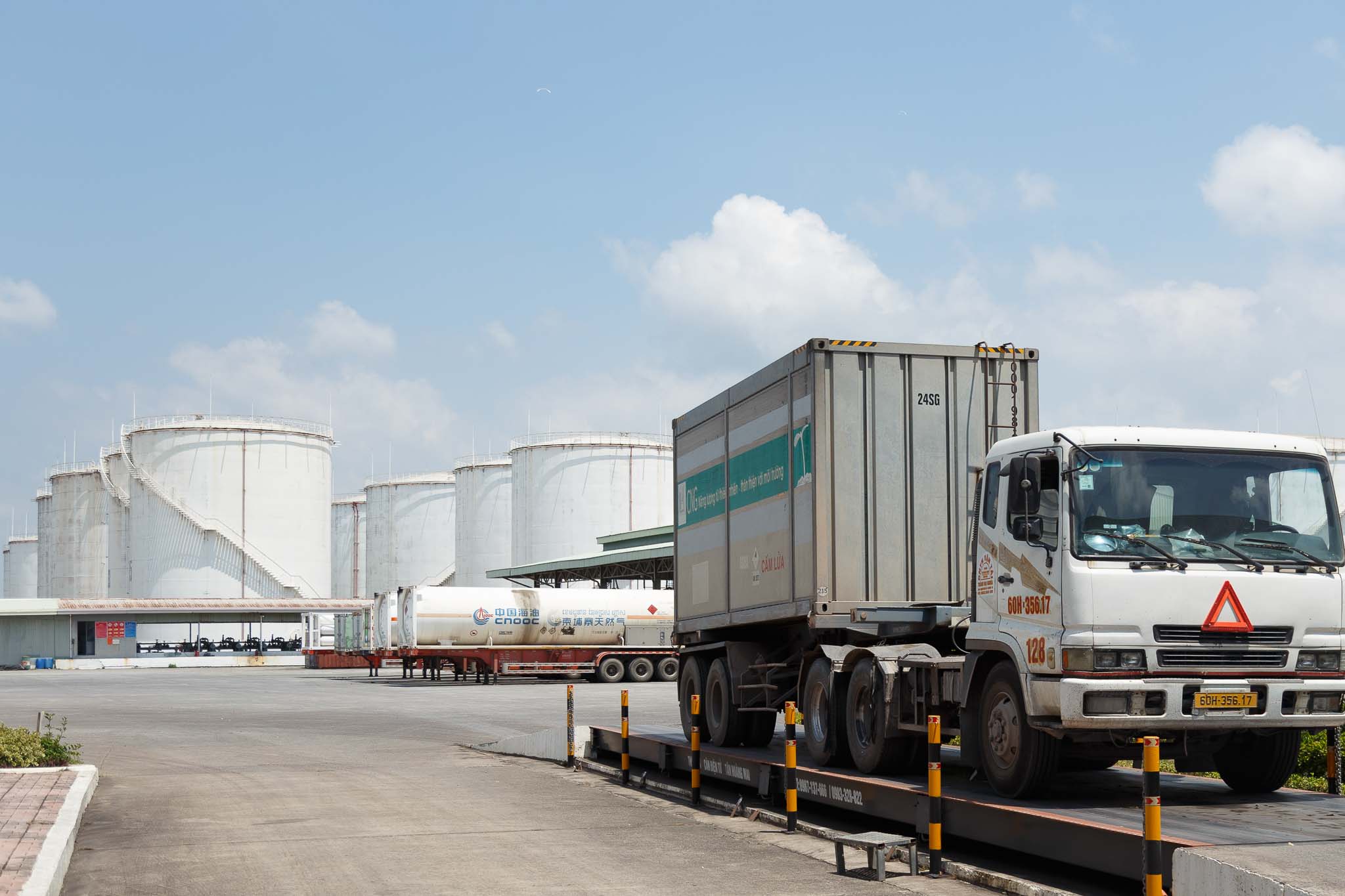 delivery truck in front of giant silos in a LPG company