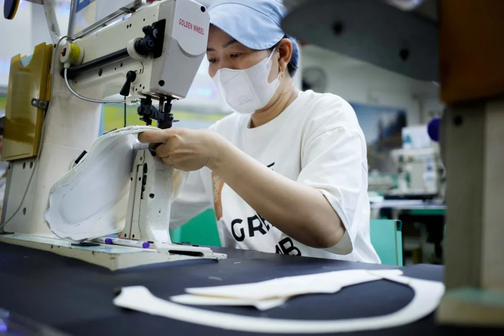 a woman sews part of shoes with sewing machine