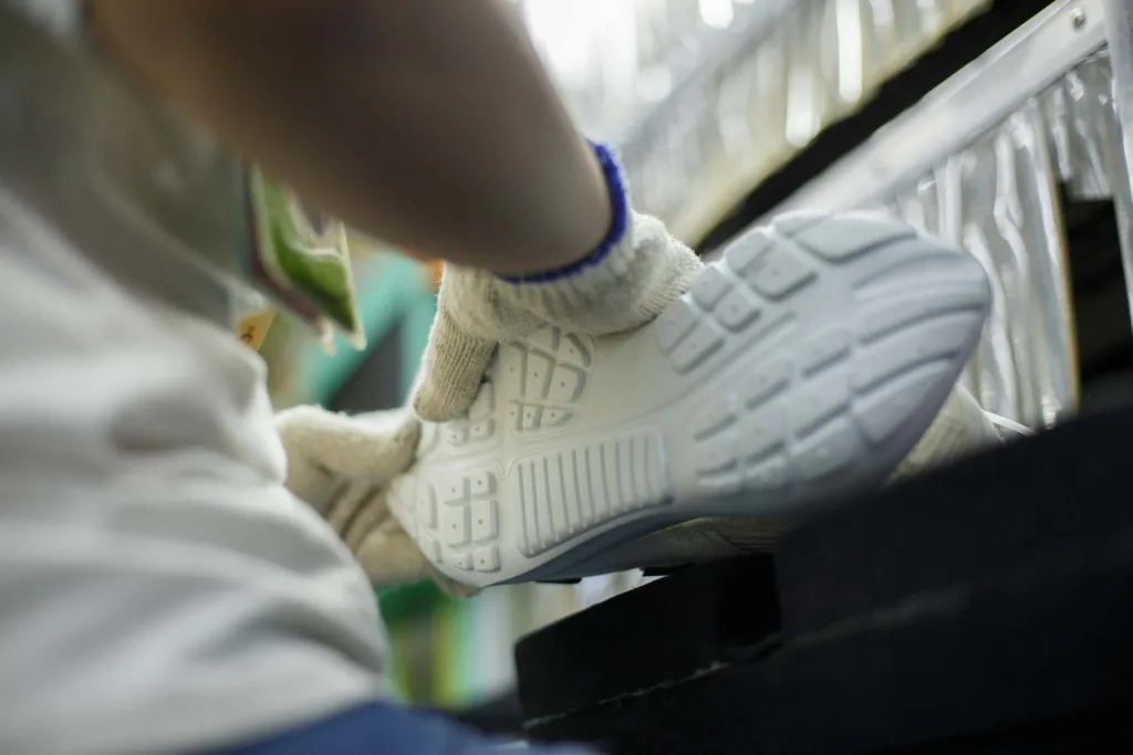 worker glues shoes upper and the sole together