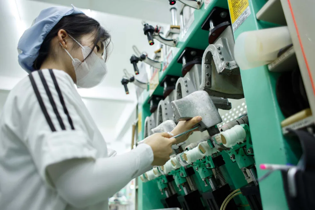 woman worker adjust the shoe pressing machine in factory